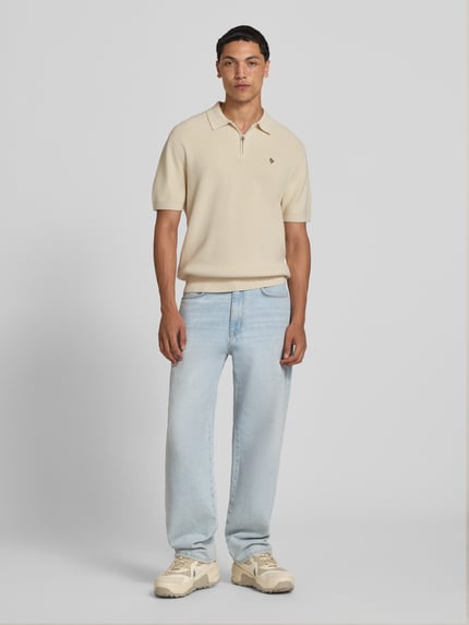 Männermodel trägt Boxy Fit Poloshirt mit logo-stitching van REVIEW in beige, puur katoen, polokraag, ritssluiting, ruglengte maat M 67 cm, ganzlichaamsvooraanzicht