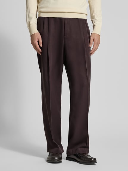 Męski model nosi spodnie z zakładkami w pasie Wide Leg Bundfaltenhose aus Lyocell Modell 'C-PAT-BB-DPL-262' von BOSS, jednokolorowe, szerokie nogawki, kanty, szlufki, zapięcie na zatrzask i kryty zamek błyskawiczny, wpuszczane i tylne kieszenie, materiał: lyocell; całkowity widok z przodu.