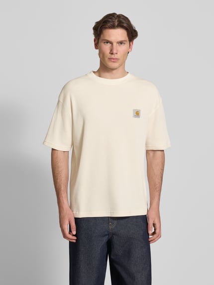 Männermodel trägt Herren T-Shirt mit Strukturmuster Modell 'Nelson' von Carhartt Work In Progress in Creme, Reine Baumwolle, Relaxed-Fit, Label-Detail, Rundhalsausschnitt, Rückenlänge bei Größe M 70 cm, Ganzkörperansicht von vorne.