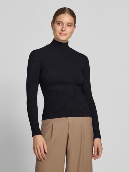 Modelka nosi czarną, prążkowaną bluzkę z długim rękawem Slim Fit Langarmshirt aus Baumwoll-Mix Modell 'Driza_4' od HUGO, damski t-shirt, widok z przodu całej sylwetki