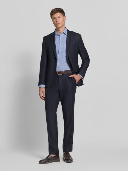 Männermodel trägt Comfort Fit Businesshemd mit Brusttasche von OLYMP, gestreiftes Allover-Muster in Blau, Ganzkörperansicht von vorne.