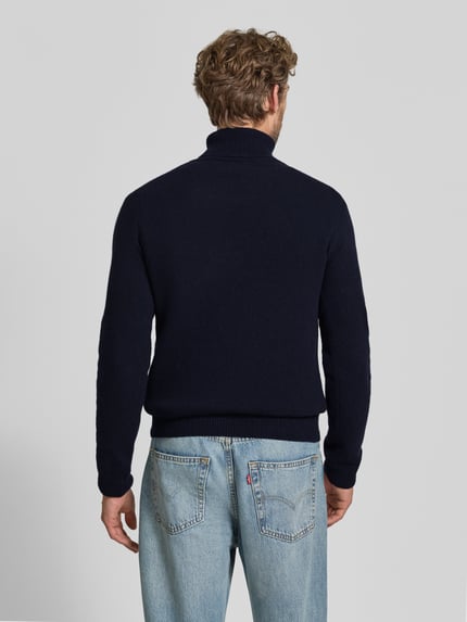 Męski model nosi Slim Fit Rollkragenpullover aus Woll-Mix Modell 'Karl' von Casual Friday, granatowy, prążkowane wykończenia, długie rękawy, długość tyłu w rozmiarze M: 70 cm, długość rękawów w rozmiarze M: 69 cm, widok całej sylwetki z tyłu.