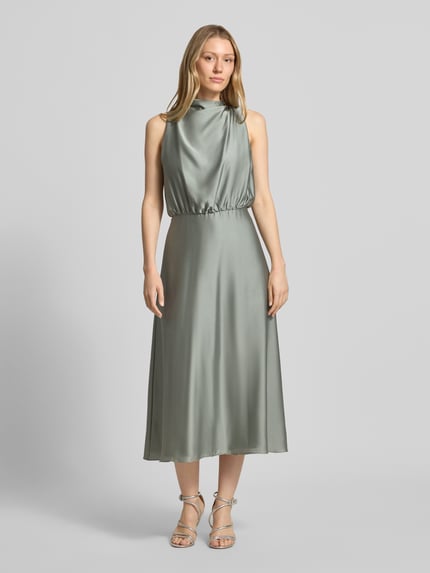 Frauenmodel trägt Cocktailkleid mit Stehkragen von Swing in zartem Mintgrün, taillierte Passform, Midikleid, Ganzkörperansicht von vorne.
