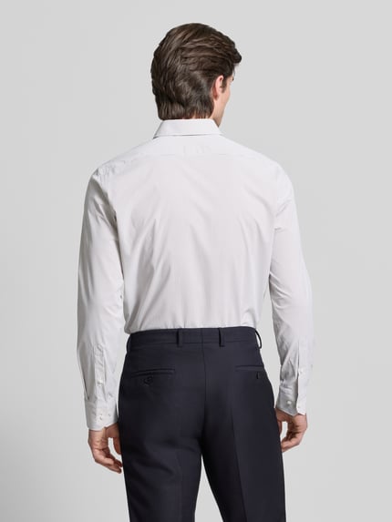 Männermodel trägt Regular Fit Businesshemd mit Kentkragen Modell 'JOE' von BOSS, weiß mit feinem Allover-Streifendesign in Webstruktur, Ganzkörperansicht Rückansicht.