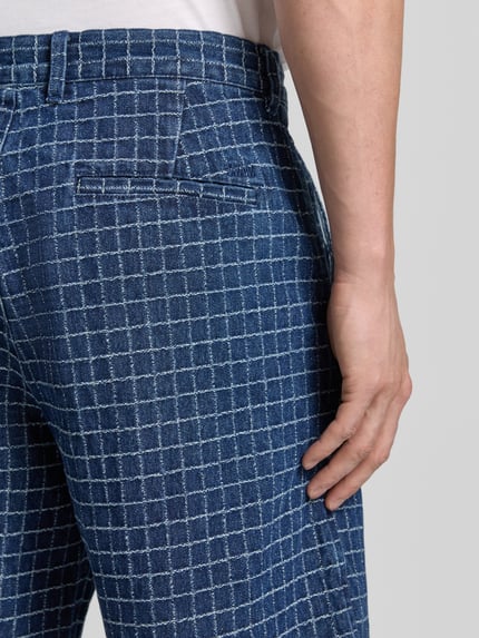 Männermodel trägt Regular Fit Bermudas met viscose model 'Luca' van Wood Wood met ruitpatroon, mix van katoen en viscose, detailaufnahme achterzak.