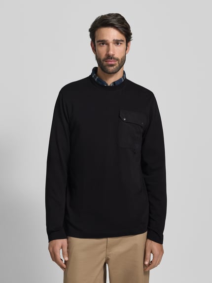 Männermodel draagt Relaxed Fit Langarmshirt uit katoenmix van Barbour, effen look, labelopschrift, metalen accenten, borstzak, ronde hals, lange mouw, Ganzkörperansicht von vorne.