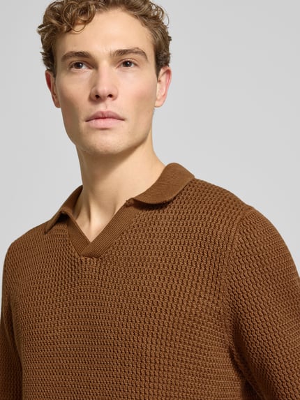 Męski model nosi Strickpullover mit gerippten Abschlüssen od MCNEAL w kolorze brązowym, dzianina bawełniana, regular fit, resortowy kołnierz, V-neck, zdjęcie: zbliżenie na górną część ciała.