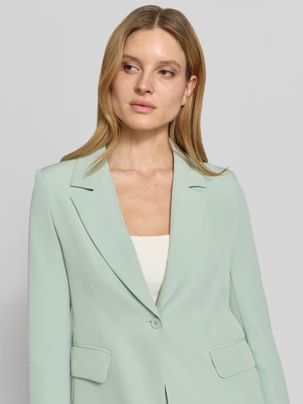 Frauenmodel trägt Blazer mit Pattentaschen Modell 'Isa' von GUIDO MARIA KRETSCHMER WOMAN in Mint mit Reverskragen, Material-Mix, Nahaufnahme Oberkörper