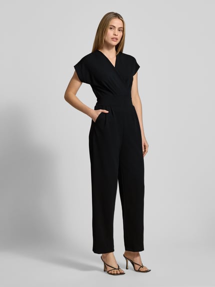 Frauenmodel trägt schwarzen Jumpsuit mit V-Ausschnitt und Eingrifftaschen, Modell 'Ko44a' von ZABAIONE, Material-Mix mit Stretch-Anteil, Regular-Fit, Ganzkörperansicht von vorne.