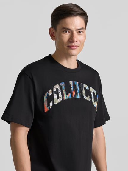 Männermodel trägt T-Shirt mit 1/2-Arm von COLUCCI in Schwarz, reiner Baumwolle, gerader Schnitt, Rundhalsausschnitt, Nahaufnahme Oberkörper.