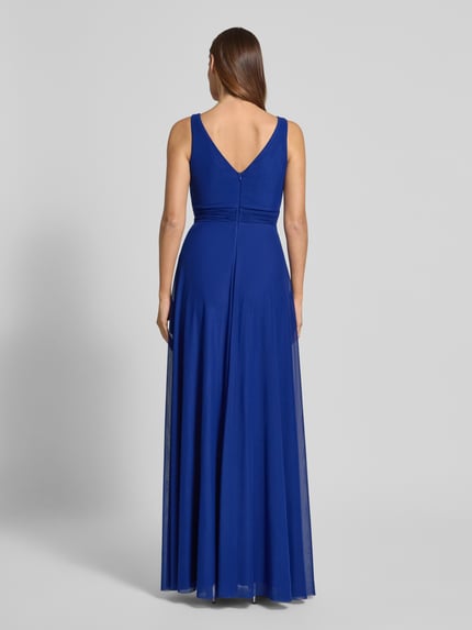 Frauenmodel trägt Abendkleid mit V-Ausschnitt und rückseitigem Reißverschluss von TROYDEN COLLECTION in kräftigem Blau, taillierter Schnitt, Maxikleid, Wickel-Optik, Rückenlänge 140 cm, Brustweite 34 cm, Ganzkörperansicht Rückansicht.
