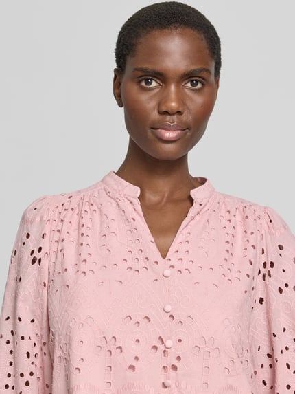 Frauenmodel trägt Knielanges Kleid mit Lochstickerei von More & More in Rosa, Baumwoll-Mix, A-Linie, Nahaufnahme Oberkörper. Rückenlänge bei Größe 36: 98 cm, Brustweite bei Größe 36: 42 cm, Ärmellänge bei Größe 36: 46 cm.