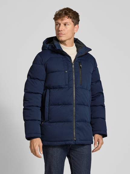 Männermodel trägt dunkelblaue Steppjacke mit Brusttasche von S.OLIVER CASUAL, strukturierte Optik, Kapuze, Frontreißverschluss, Ganzkörperansicht von vorne.