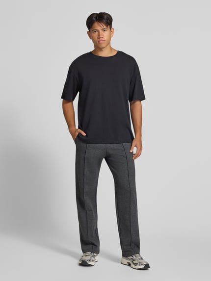 Männermodel trägt Straight Fit Sweatpants mit elastischem Bund von REVIEW in Dunkelgrau, Baumwoll-Mix, Bügelfalte, Ganzkörperansicht von vorne.