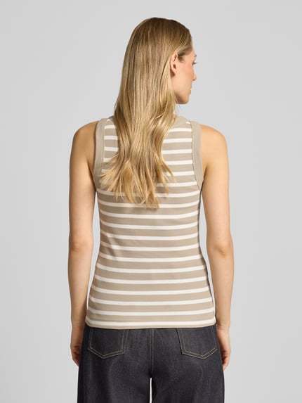 Vrouwenmodel draagt Tanktop met Rippenstructuur Model 'OLINA' van Drykorn in beige-wit katoen, slim fit, ronde hals, ruglengte 55 cm, volledige achterkantaanzicht.