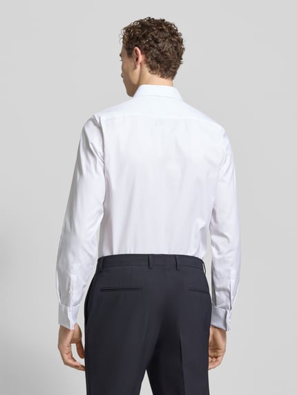 Männermodel trägt Slim Fit Business-Hemd mit Knopfleiste von Eterna aus reiner Baumwolle, Haifischkragen, Ganzkörperansicht Rückansicht.