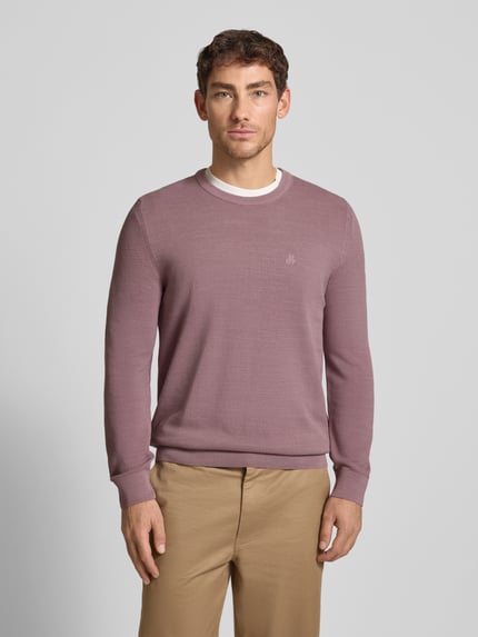 Männermodel trägt Regular Fit Strickpullover aus reiner Baumwolle von Marc O'Polo, Optik: Unifarben, Logo-Stitching, Rundhals, Langarm, gerippte Abschlüsse, Materialverarbeitung: Strick, Farbe: leicht mattes Rosa, Struktur: fein, Ganzkörperansicht von vorne.