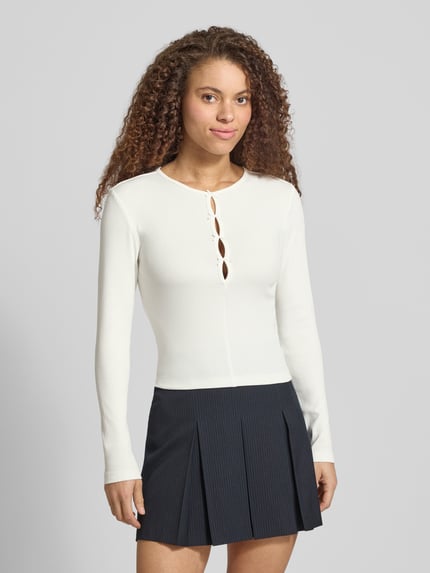 Frauenmodel trägt Slim Fit Langarmshirt aus Baumwoll-Mix Modell 'FEMKE' von Only in Unifarben, Feinripp, Rundhals, Ganzkörperansicht von vorne.