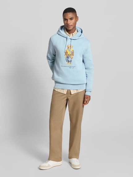 Männermodel trägt Hoodie mit Kapuze von Polo Ralph Lauren, hellblau, Baumwoll-Mix, Lockerer-Schnitt, Label-Print, Gerippte-Abschlüsse, Ganzkörperansicht von vorne.