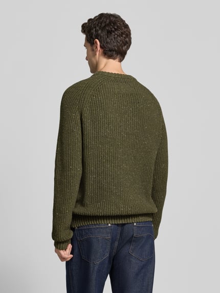 Männermodel trägt Pullover mit Raglanärmeln Modell 'KIAANO' von ARMEDANGELS in melierter Strickoptik, Grünton, Ganzkörperansicht Rückansicht.