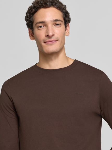 Männermodel trägt Langarmshirt mit Rundhalsausschnitt von S.OLIVER CASUAL, braun, unifarben, weiche Textur, Nahaufnahme Oberkörper.