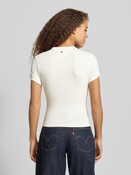 Frauenmodel trägt Slim Fit T-Shirt aus Baumwoll-Mix Modell 'SLIM VARSITY' von Tommy Jeans, Optik: unifarben, Ganzkörperansicht Rückansicht.
