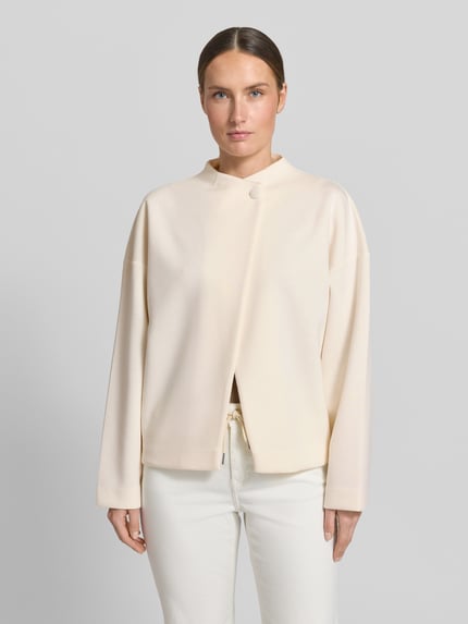 Frauenmodel trägt Jacke Viskose-Mix mit Knopfverschluss von Rich & Royal in Creme, Relaxed Fit, Stehkragen, Ganzkörperansicht von vorne.