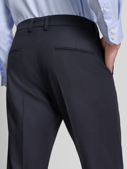 Männermodel trägt Anzughose mit Bügelfalten Modell 'AJEND' von Drykorn, dunkelblauer Material-Mix mit Woll-Anteil, Regular-Fit, Detailaufnahme Rückansicht. Bundweite 33 cm, Innenbeinlänge 78 cm bei Größe 50.
