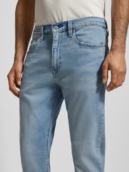 Männermodel trägt Tapered Fit Jeans Modell '502™' von Levi's®, hellblau, Baumwoll-Elasthan-Mix, 5-Pocket-Design, Nahaufnahme Oberkörper.