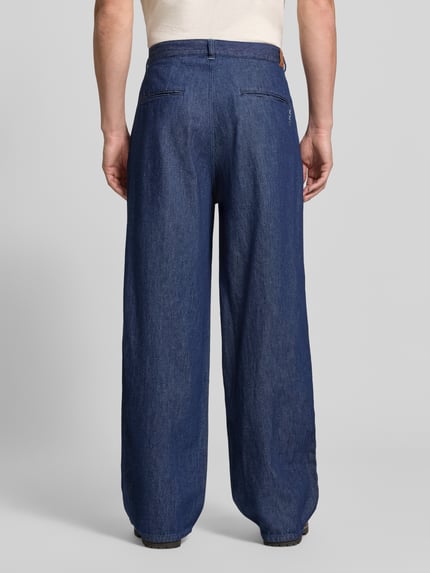 Männermodel trägt Loose Fit Jeans mit Eingrifftaschen von Scotch & Soda, blauer Baumwoll-Lyocell-Mix, Ganzkörperansicht Rückansicht.