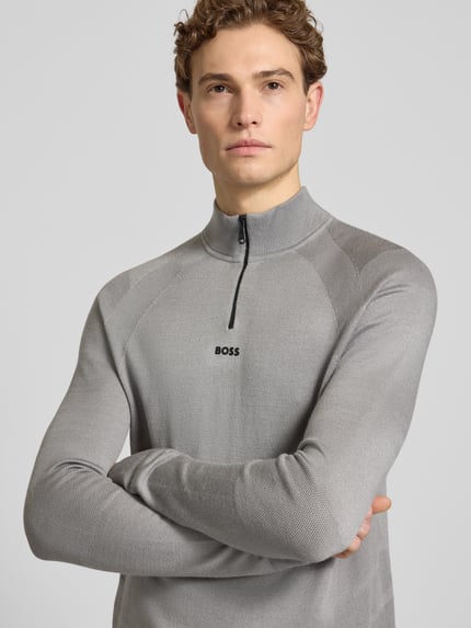Mannemodel draagt Regular Fit Troyer met Schurwoll-Anteil model 'TOUR SEAMLESS QZ' van BOSS Green, look: effen, jacquard, lange mouw, labelopschrift en labelstitching, schipperskraag met ritssluiting, rompzoom en mouwboord geribd, Nahaufnahme bovenlichaam.