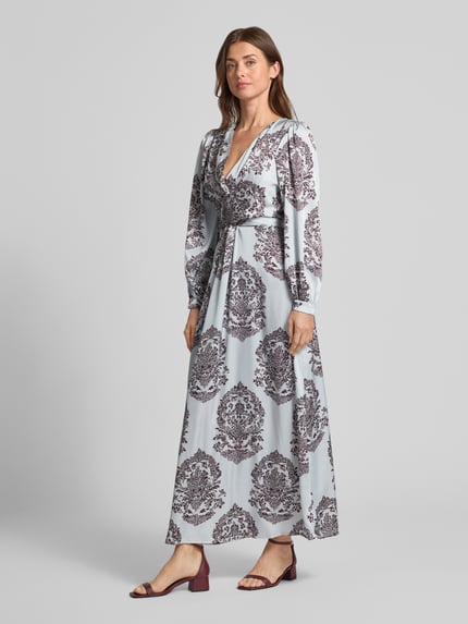 Frauenmodel trägt Maxikleid mit V-Ausschnitt Modell 'Bretti' von Neo Noir in Satin mit tailliertem Schnitt und Print, Ganzkörperansicht von vorne.