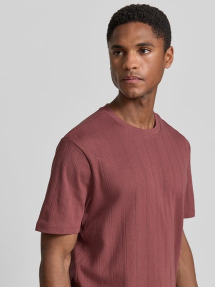 Männermodel trägt Regular Fit T-Shirt mit Allover-Loch-Stitching von JAKE*S STUDIO MEN aus Reine Baumwolle in Rot, Nahaufnahme Oberkörper. Rückenlänge bei Größe M: 68 cm, Kurzärmelig, Rundhalsausschnitt.