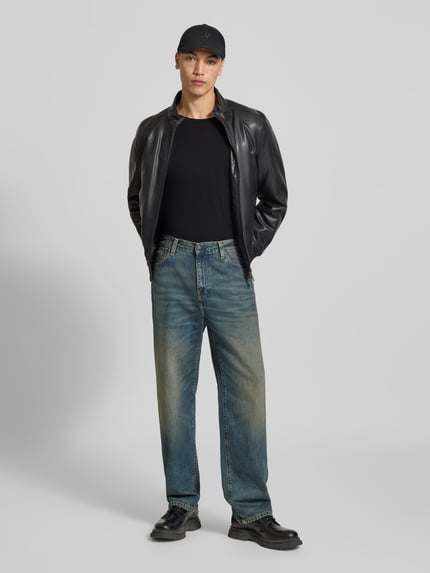 Męski model trägt T-Shirt mit Rollsaum von Filippa K z bawełny, prosty krój, okrągły dekolt, długość tyłu 70 cm w rozmiarze M, Ganzkörperansicht von vorne.