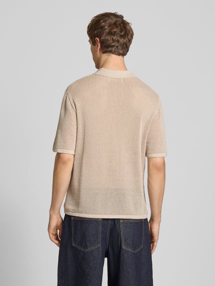 Männermodel trägt Regular Fit Strick-Poloshirt Modell 'CASSIS' von Jack & Jones in Beige, reine Baumwolle, Rückansicht, Ganzkörperansicht.
