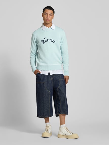 Męski model nosi Leinenpullover aus Leinen-Mix von Kenzo, mieszanka lnu i bawełny, luźny krój, wyhaftowane logo, prążkowane wykończenia, paski w kontrastowym kolorze, długość tyłu w rozmiarze M: 66 cm, widok całofigurowy z przodu.