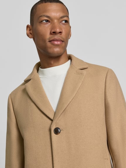 Männermodel trägt Regular Fit Mantel aus Woll-Mix mit Viskose-Anteil von Matinique in Beige mit Reverskragen, Nahaufnahme Oberkörper.