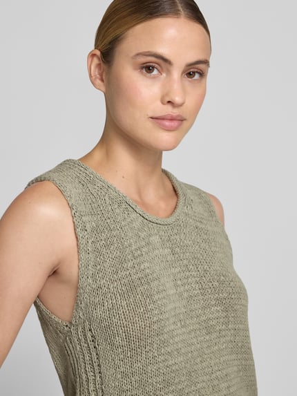 Modelka kobieca ma na sobie top z dzianiny z mieszanki bawełny z okrągłym dekoltem Stricktop aus Baumwoll-Mix mit Rundhalsausschnitt od Oui, krój regular fit, kolor szary, delikatna faktura, długość tyłu w rozmiarze 36: 52 cm, zbliżenie na górną część ciała z przodu.