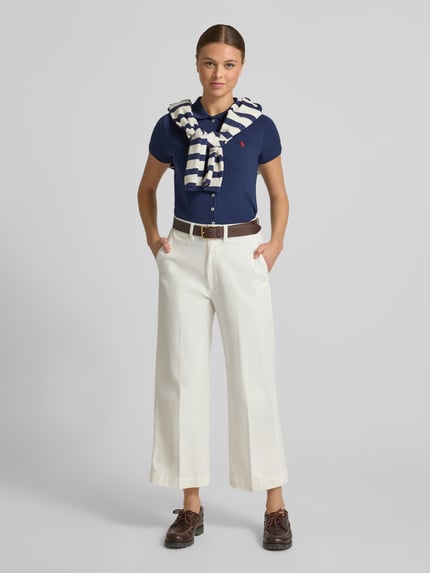 Vrouwenmodel draagt Poloshirt met knoopsluiting van Polo Ralph Lauren, mix van katoen en elastaan, slim fit, overhemdkraag, labelstitching. Ganzkörperansicht von vorne.