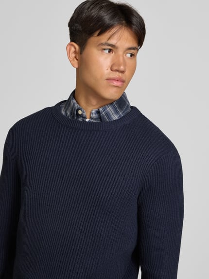 Männermodel trägt Strickpullover mit Rundhalsausschnitt Modell 'PANNEL' von JACK & JONES, dunkelblau, Baumwoll-Mix, Nahaufnahme Oberkörper.