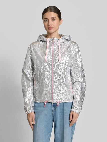 Vrouwenmodel draagt Jacke met Kapuze Modell 'MAY' van Frieda & Freddies in zilver met dierenprint, recht model, zij-ritszakken, tweewegritssluiting, elastische mouwboord, tunnelkoord aan capuchon en zoom, vooraanzicht van het volledige lichaam. Ruglengte maat 36: 58 cm, schouderbreedte 50 cm, borstwijdte 56 cm, mouwlengte 63 cm.