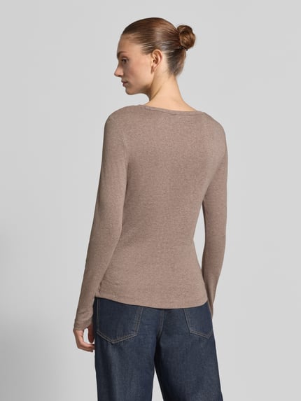 Frauenmodel trägt Slim Fit Langarmshirt aus reiner Baumwolle von s.Oliver RED LABEL in Beige, glatte Textur, Ganzkörperansicht Rückansicht.
