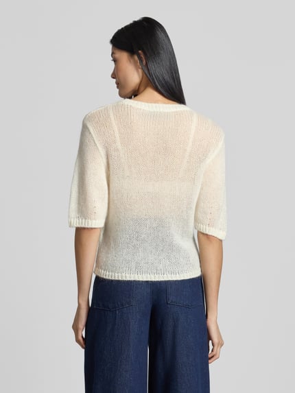 Frauenmodel trägt Regular Fit Pullover aus Schurwoll-Modal-Mix Modell 'C_Farezza' von BOSS, cremefarben, grob gestrickt, lockerer Schnitt, Damen Pullover von BOSS Orange, Ganzkörperansicht Rückansicht.