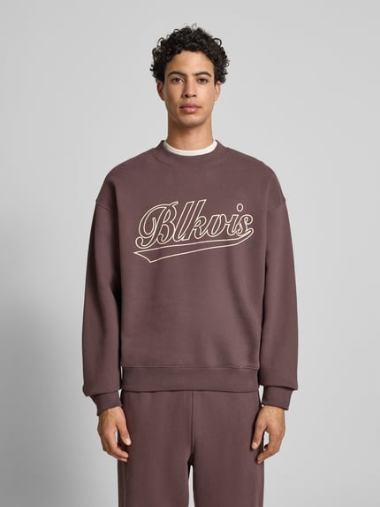 Männermodel trägt Regular Fit Sweatshirt mit Logo-Print Modell 'Source' von BLKVIS aus reiner Baumwolle, Rundhalsausschnitt, elastische Abschlüsse, Farbton Braun, Ganzkörperansicht von vorne.