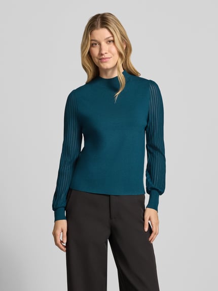 Modelka kobieca ma na sobie Regular Fit Strickpullover mit Stehkragen od zero z mieszanki wiskozy, krój regular fit, dopasowany, widok całej sylwetki z przodu.