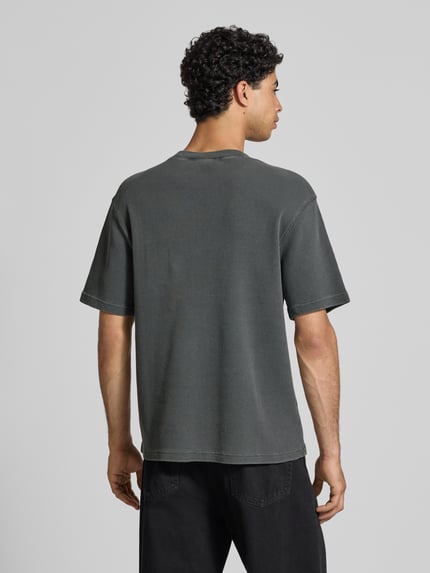 Männermodel draagt T-shirt met structuurpatroon model 'Nelson' van Carhartt Work In Progress, puur katoen, relaxed fit, labeldetail, ronde hals, ruglengte maat M 70 cm, ganzkörperansicht rückansicht.