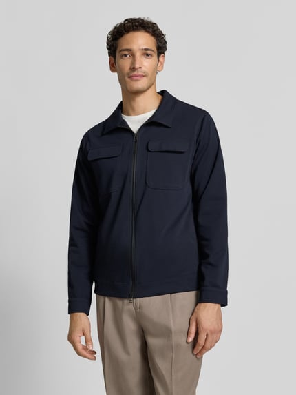 Männermodel trägt Regular Fit Hemdjacke mit Viskose-Mix Modell 'Taylor' von Zuitable in Dunkelblau, Vorderansicht, Nahaufnahme Oberkörper. Elastischer Material-Mix, Umlegekragen, Zweiwege-Reißverschluss, aufgesetzte Brusttaschen.