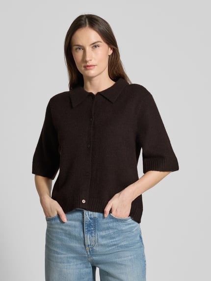 Frauenmodel trägt Regular Fit Hemdbluse mit Woll-Anteil Modell 'Cunna' von Neo Noir in dunklem Braun, Strick-Optik, Halbarm, Nahaufnahme Oberkörper.