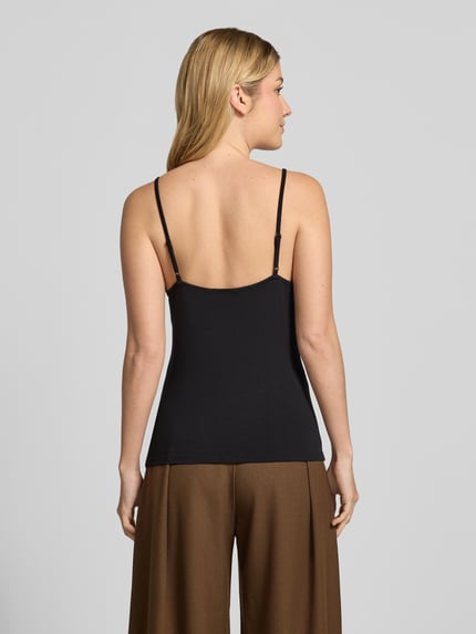 Frauenmodel trägt Slim Fit Trägertop aus elastischem Viskose-Mix Modell 'OKTOBER' von COMMA in Schwarz, Ganzkörperansicht Rückansicht. Rückenlänge bei Größe 36: 35 cm, verstellbare Träger, V-Ausschnitt.