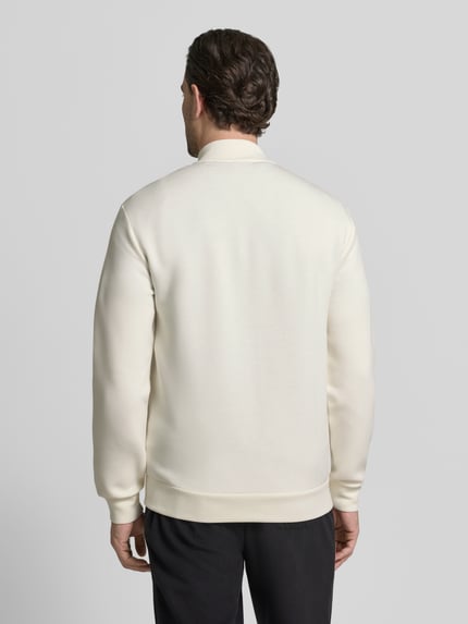 Mężczyzna nosi Sweatjacke mit Reißverschluss od EA7 Emporio Armani, kremowa, krój regular fit, ściągacze, długość tyłu 70 cm, rękawy 66 cm, widok całej sylwetki z tyłu.